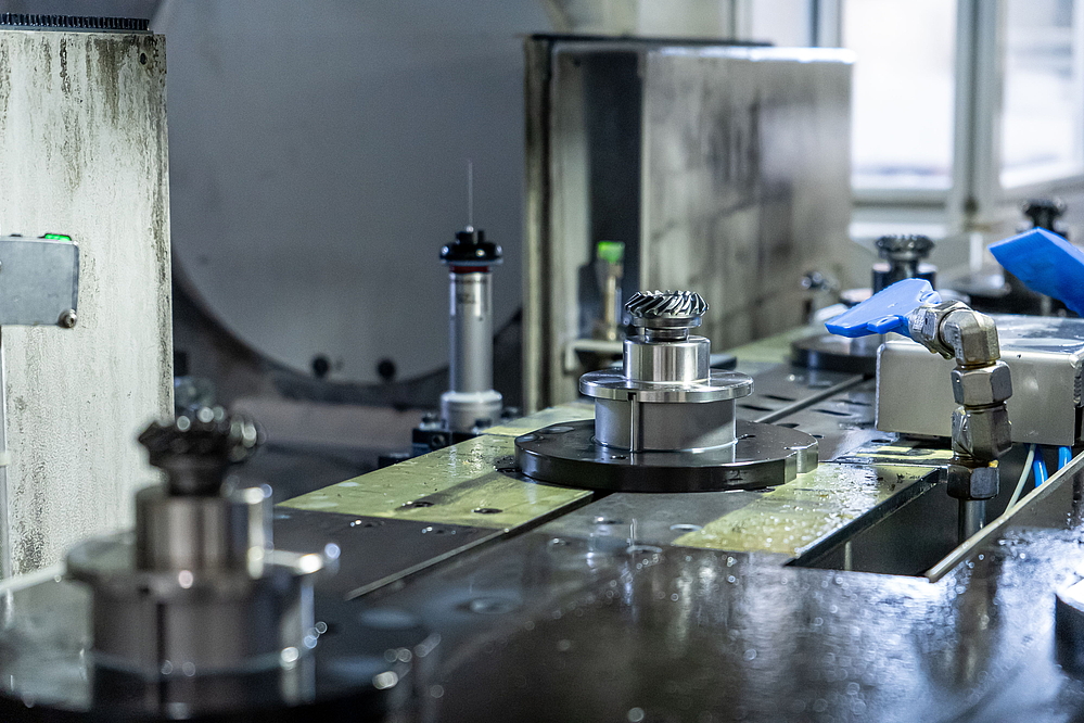 VSC 400 DDS 的旋转分度传送装置上工件托架上的锥齿轮 - 在 EWS，拾取主轴可精确且可重复地取出工件，用于硬加工。