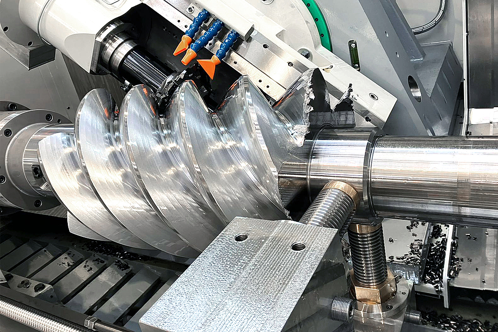 View into the work area of the CLC 500 H FR during the machining of a rotor. The powerful profile milling head mills the rotor profile with high precision. The picture shows the flexibility of the machine and the possibility of realizing large spiral angles. 
