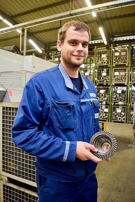 部门经理 Stephan Lücke 手持一个用 VLC 200 GT 机床加工的锥形齿轮。