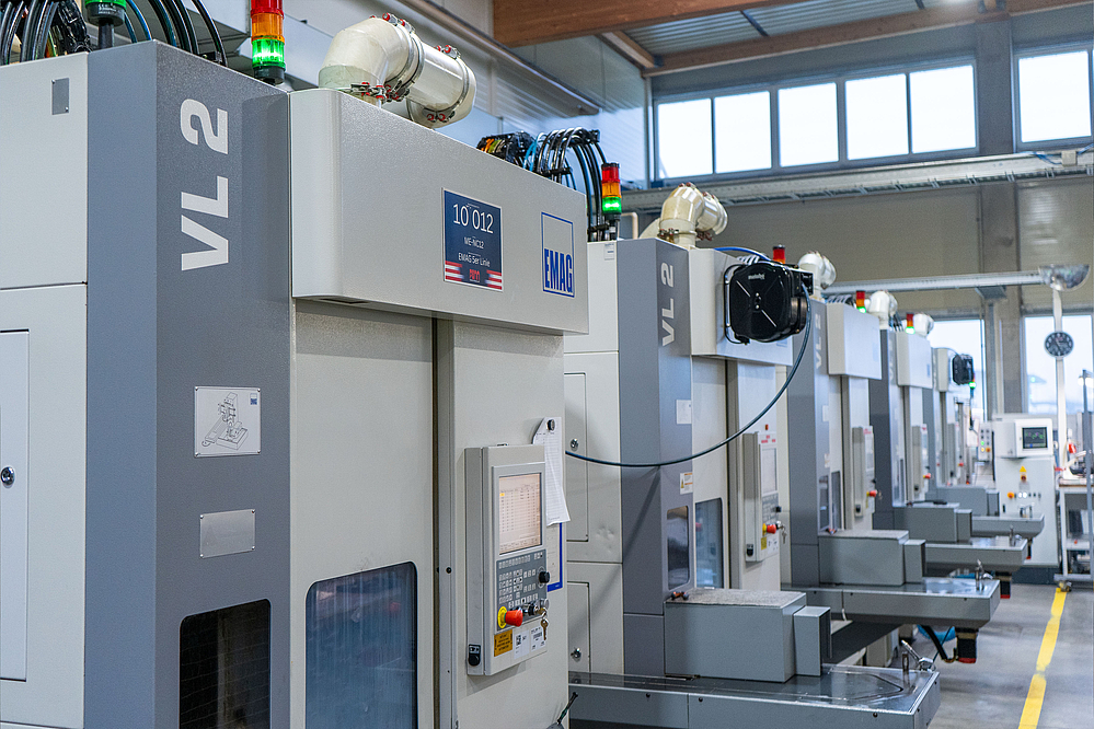 Series of interlinked EMAG VL 2 vertical turning machines in the production hall of PENN GmbH for the automated machining of forged parts.